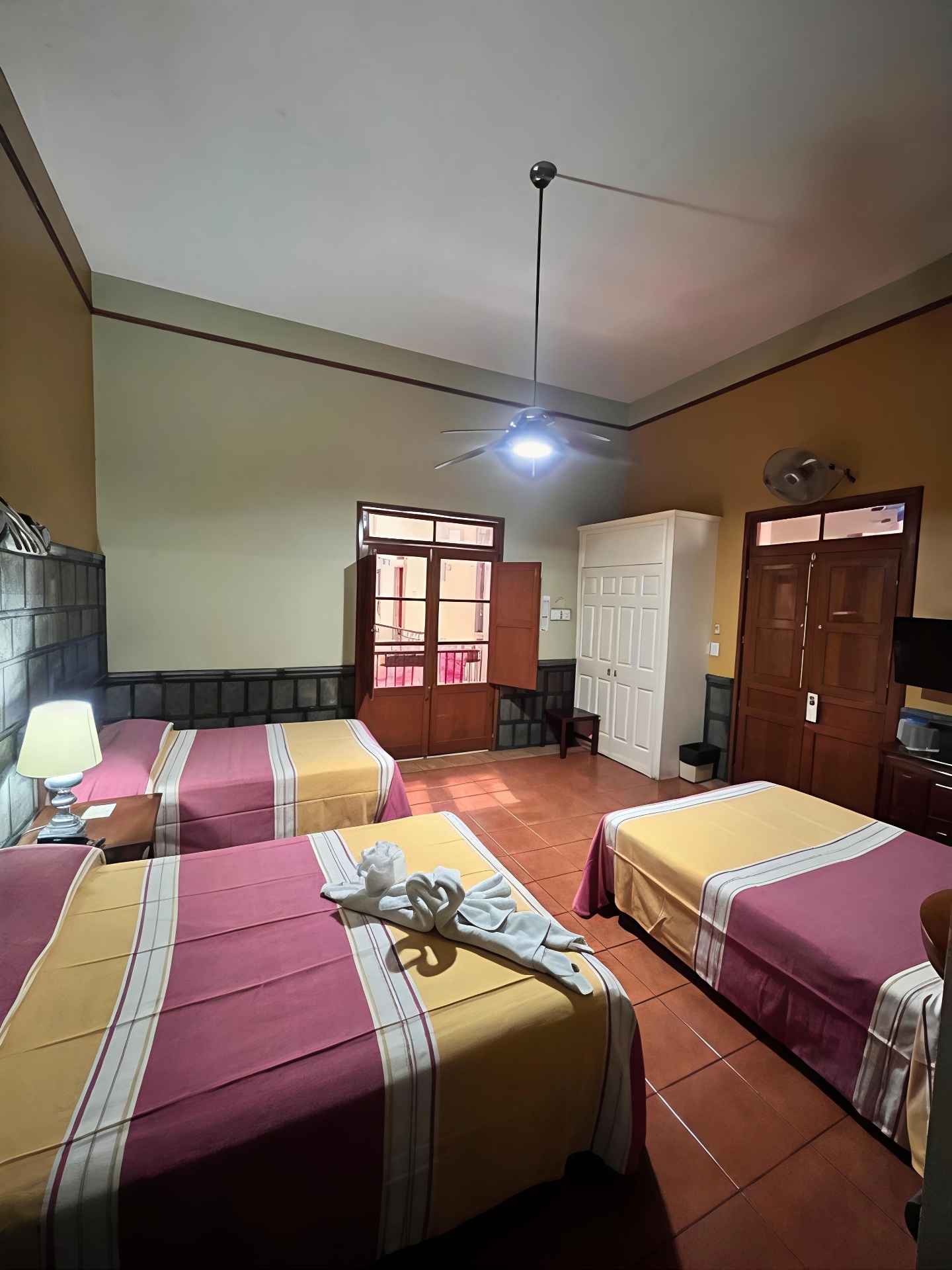 Habitación triple amplia con balcón y ventilador de techo