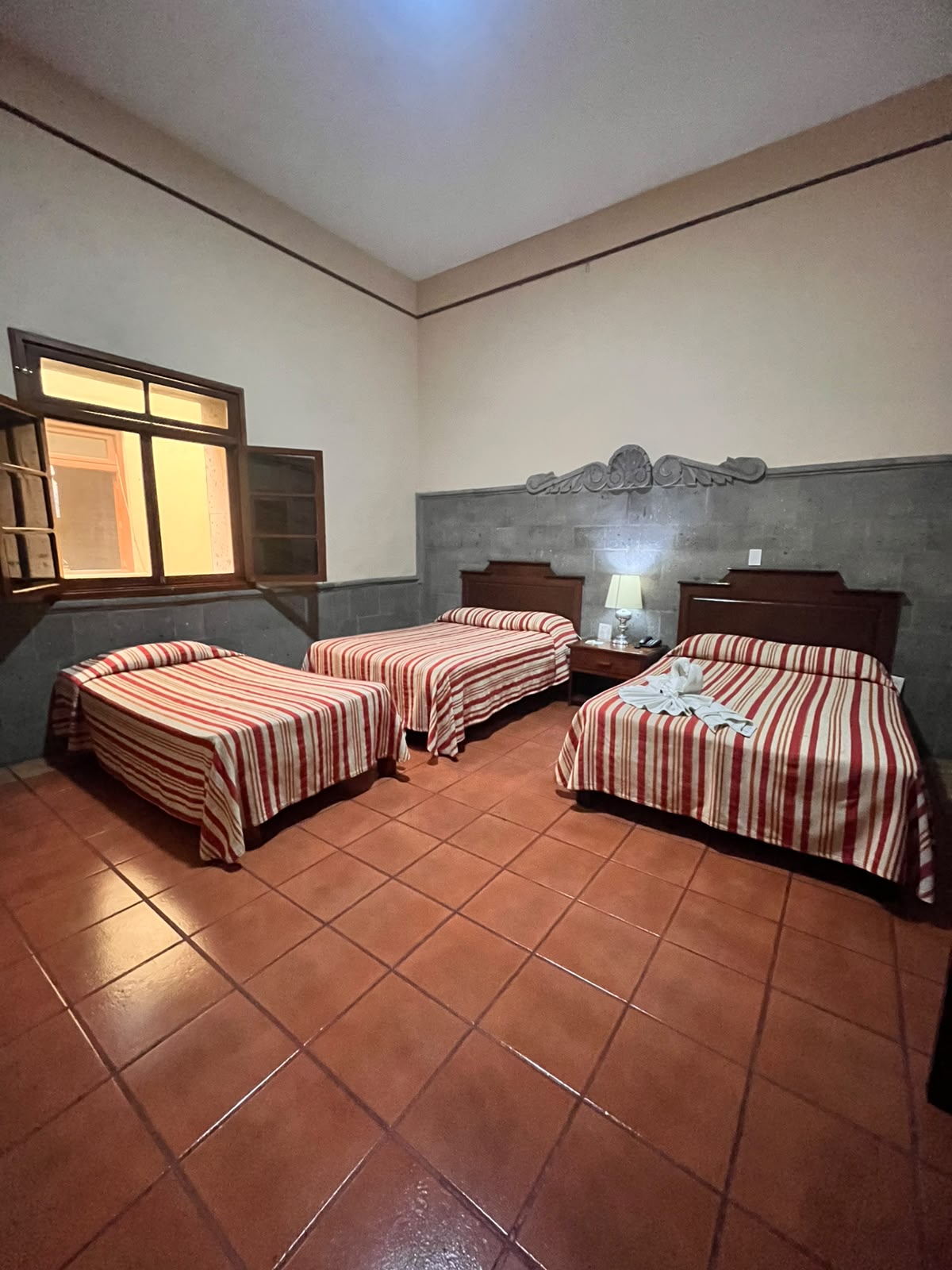 Habitación triple con tres camas y cobertores a rayas