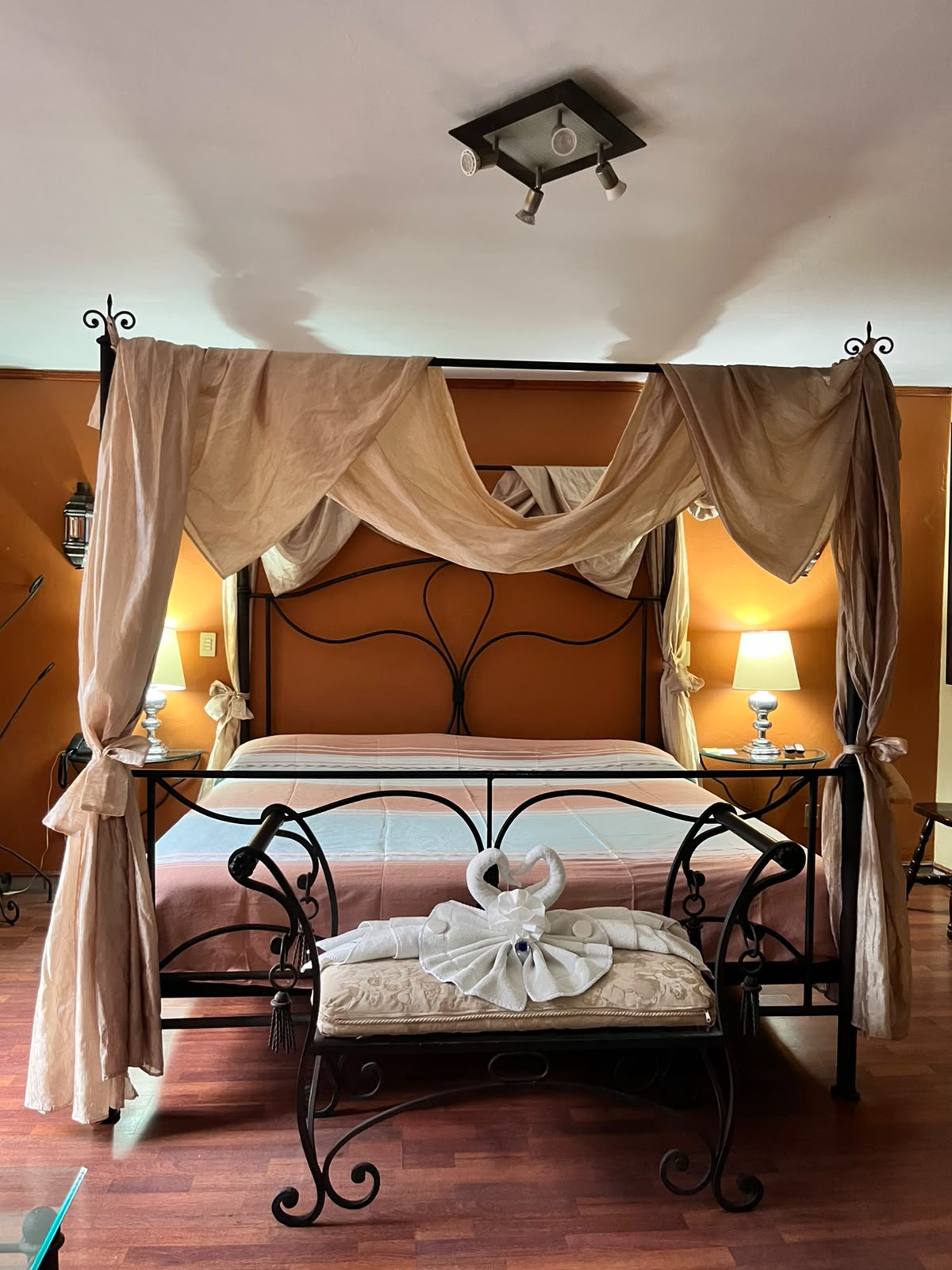 Habitación sencilla con cama con dosel y decoración de toallas