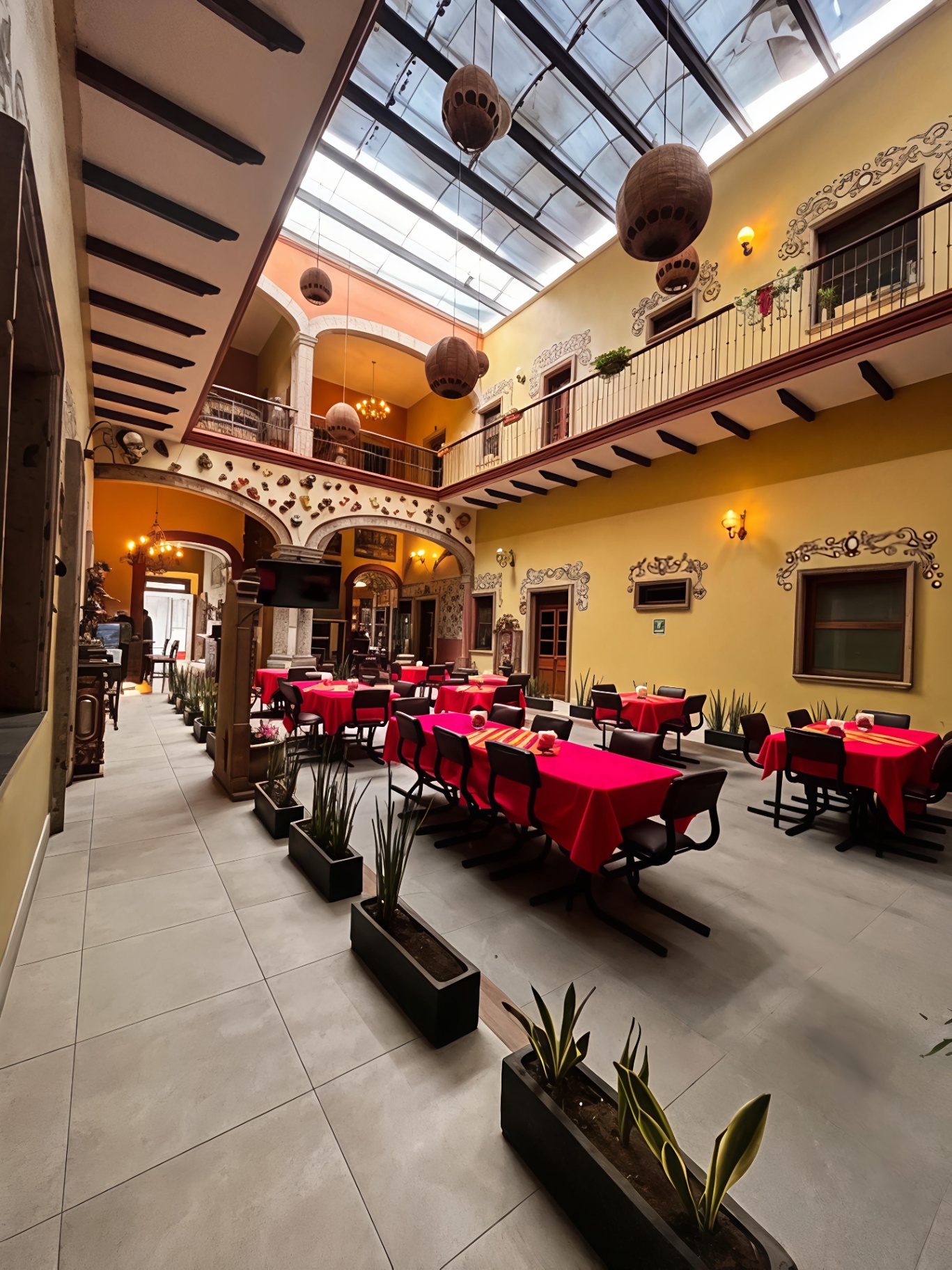 Comedor del hotel con mesas vestidas de rojo y tragaluz